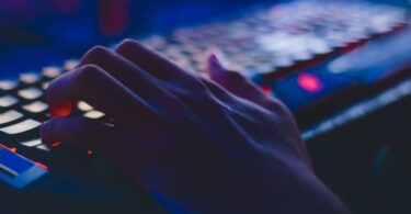 Person typing on a computer keyboard, doing data entry as online work to earn money
