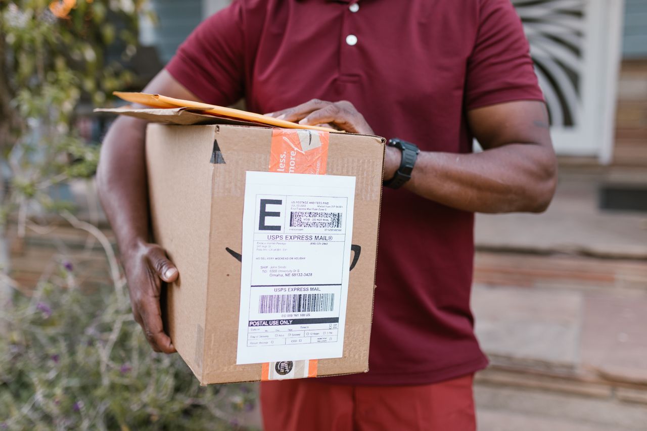 Courier carrying parcels with a mail label, like a free USPS Package Pickup instead of a drop off location
