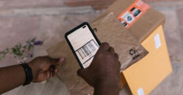 Courier scanning a package barcode with a smartphone, the scan that updates USPS tracking for where's my package