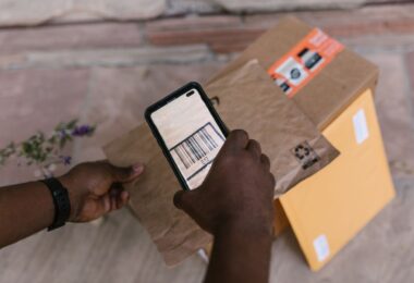 Courier scanning a package barcode with a smartphone, the scan that updates USPS tracking for where's my package
