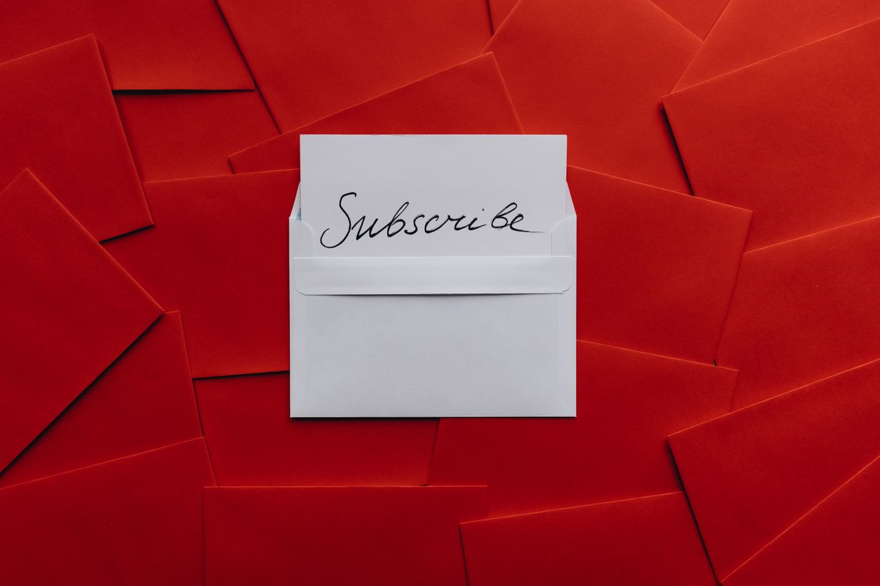 Red envelopes around a white subscribe card, illustrating Sendloop pricing for email subscribers