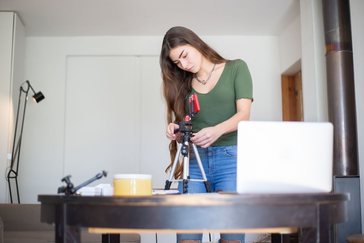 Creator setting up a tripod camera to record an online course to sell on Payhip