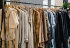Secondhand clothes hanging on a rack, ready to list as you learn how you get paid on Poshmark