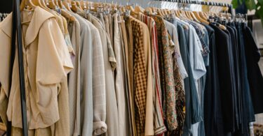 Secondhand clothes hanging on a rack, ready to list as you learn how you get paid on Poshmark