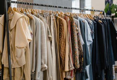 Secondhand clothes hanging on a rack, ready to list as you learn how you get paid on Poshmark