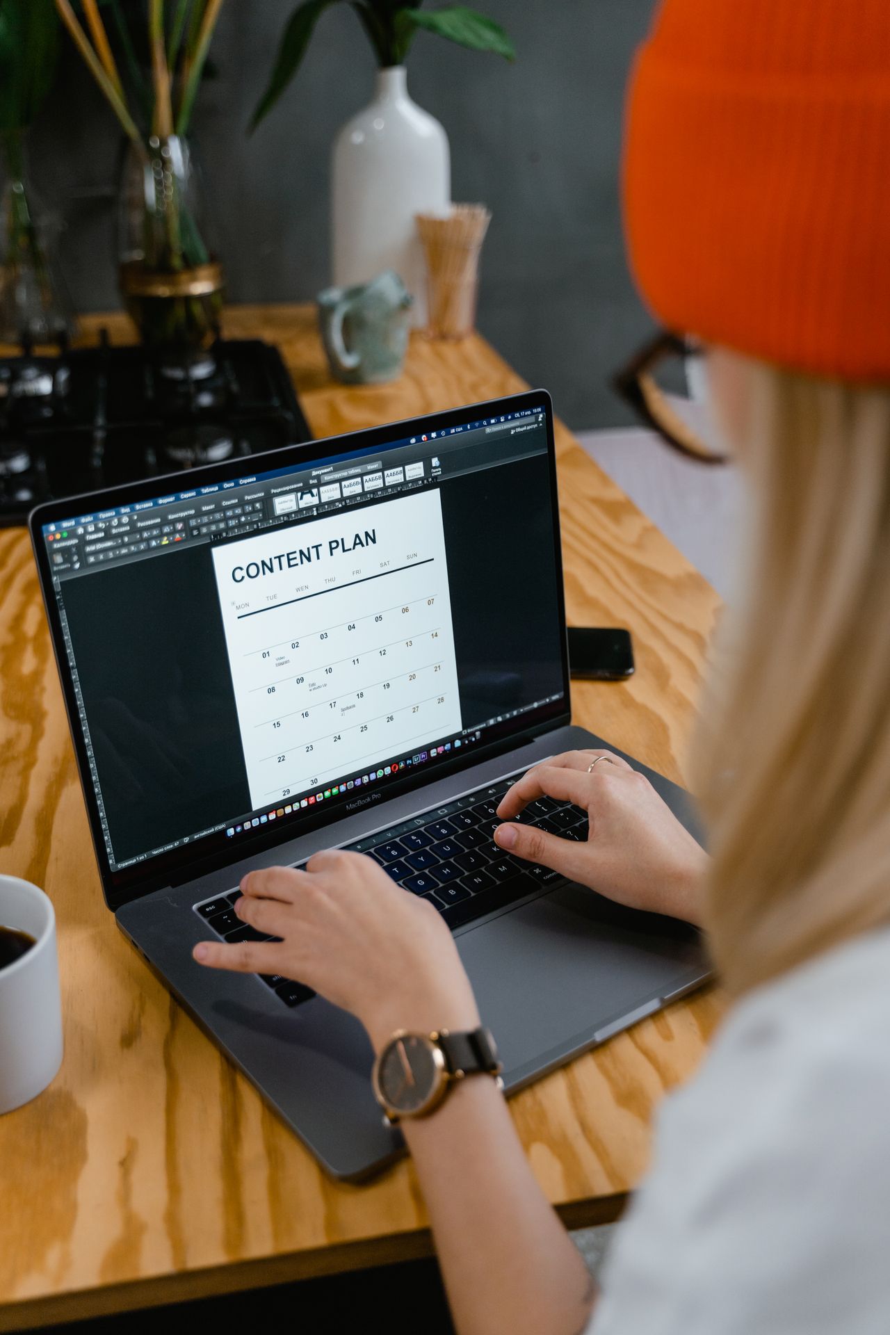 Woman planning newsletter content on a laptop before setting up MailerLite email automation