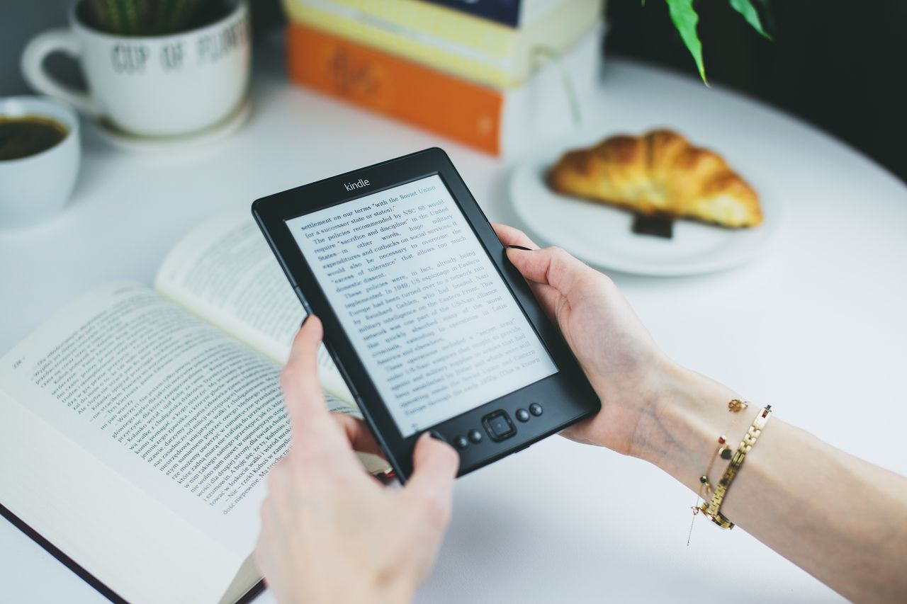 Person holding an e-reader, a reminder that self-published ebooks are one way to earn from online writing