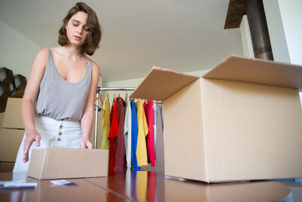 Woman packing merchandise for her small online business run on a budget