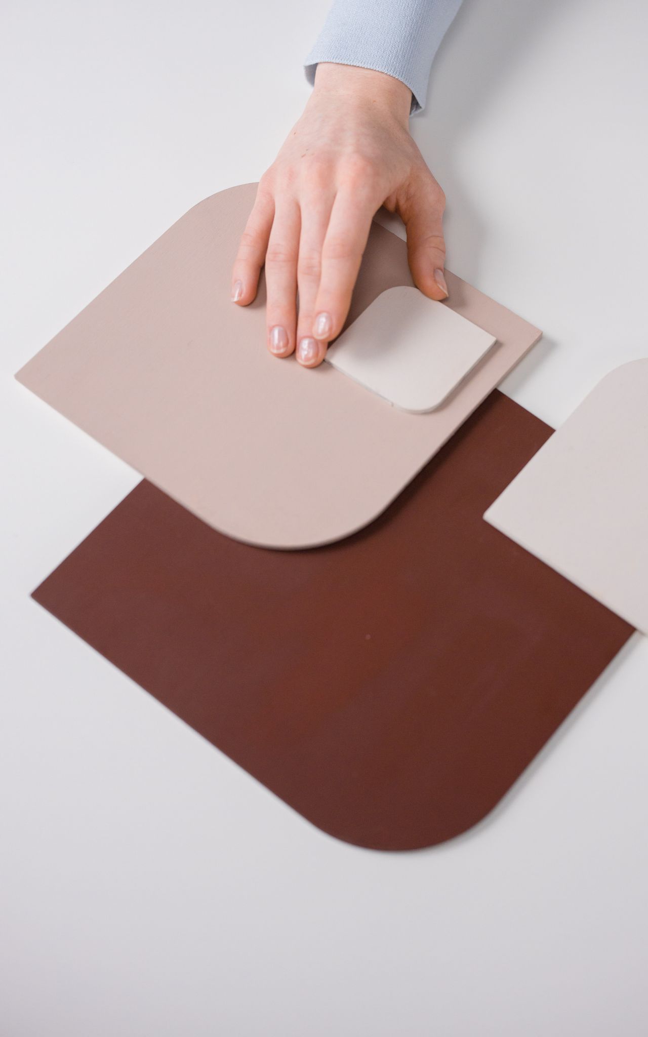 Hand on color swatch cards in many shades, matching the codes an HTML color picker gives you