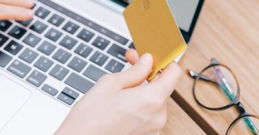Woman paying by card on a laptop at an online checkout, the step SamCart is built to optimize