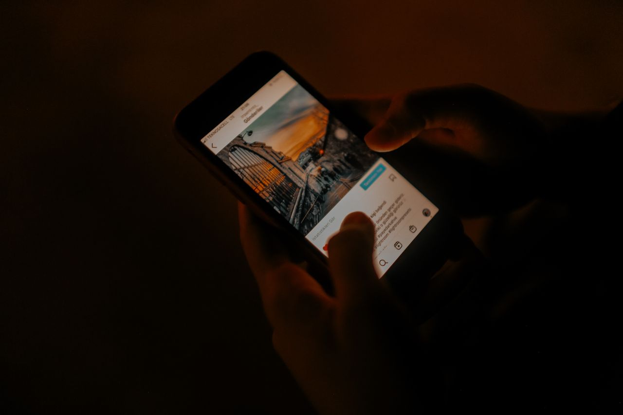 Hands holding a phone and browsing the web in low light, a common moment to use private browsing on Safari