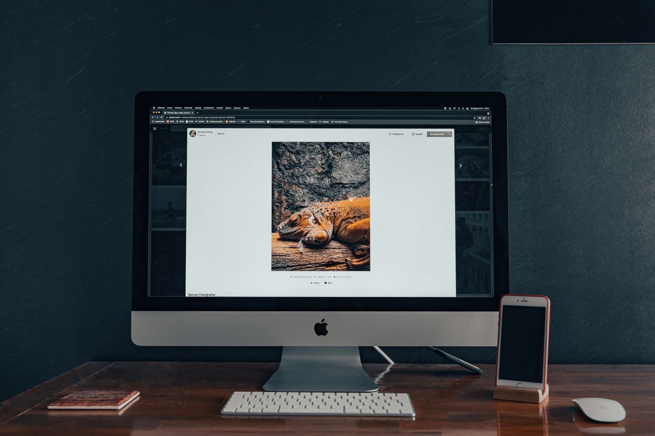 Desktop computer and smartphone on a wooden desk, a setup for using Instagram on PC or Mac