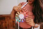 Woman holding a color wheel to choose shades, the same job an HTML color picker does on screen