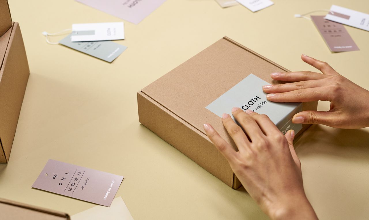 Hands packing an order into a cardboard box, as a store moves on from the old 3DCart platform