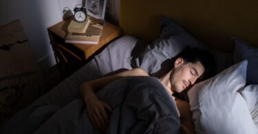 Man resting in bed in morning light, the dream behind ideas to make money while you sleep